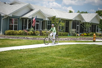 A resident biking along the pathway near the facility