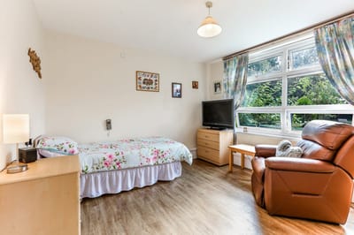 Private room with bed, chair, and TV
