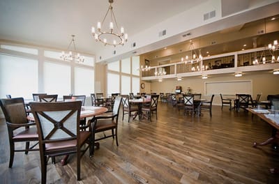 A spacious dining room with elegant lighting and furniture