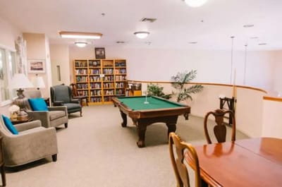 Interior common area with pool table and bookshelves