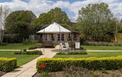 A garden with seating area and gazebo