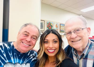Residents smiling with staff member in common area