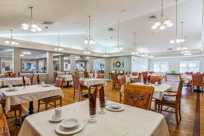 Dining room setup with tables and chairs for residents