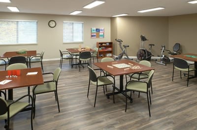 Bright interior common area with gaming tables and exercise equipment