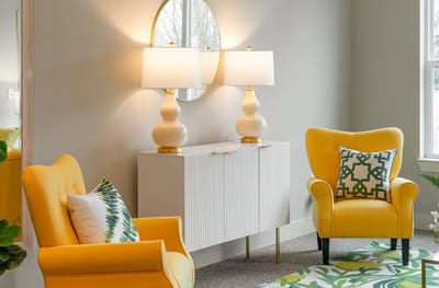 Welcoming living room area with yellow chairs and lamps