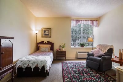 Cozy private room with bed and armchair