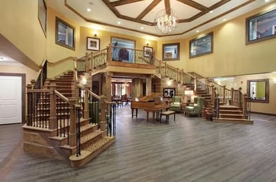Interior view of a grand lobby with staircase and piano