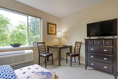 A cozy resident room with a TV and table