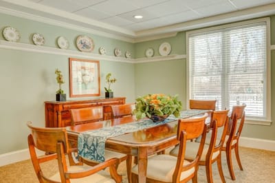Bright dining room with a wooden table and floral centerpiece