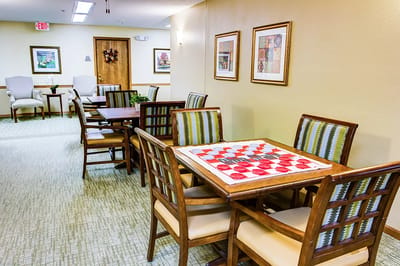 Common area with tables and chairs in a bright setting