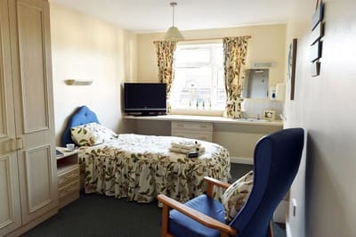 Cozy private room with bed, chair, and TV