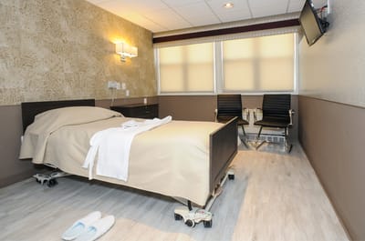 A private resident room with a bed and seating area