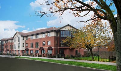 Exterior view of Berkeley House Care Home during autumn
