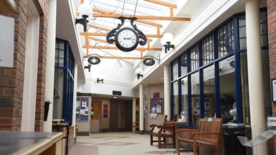 Interior hallway with seating and a large clock