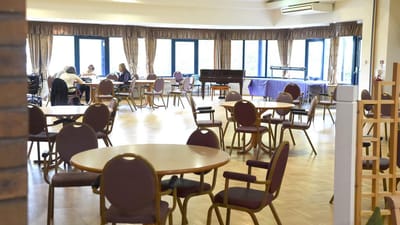 Bright common area with residents and tables