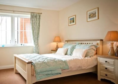 Brightly lit resident room with a cozy bed and decor