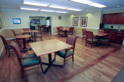 Brightly lit common area with tables and chairs