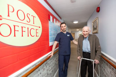 Staff assisting a resident in a hallway