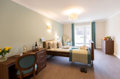 A private resident room with a bed and a desk