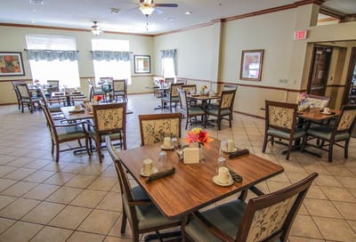 Dining area with tables and chairs set for residents