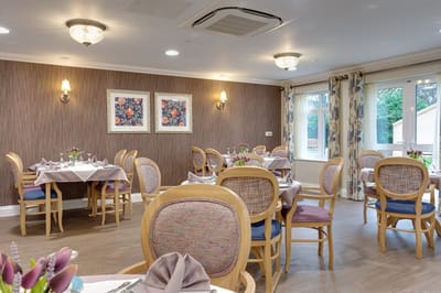 Dining room set for a meal with floral arrangements