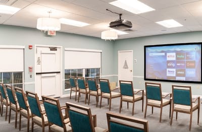 Activity room with seating and a projector screen