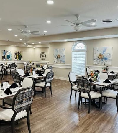 Bright dining room with floral decor and tables set for meals