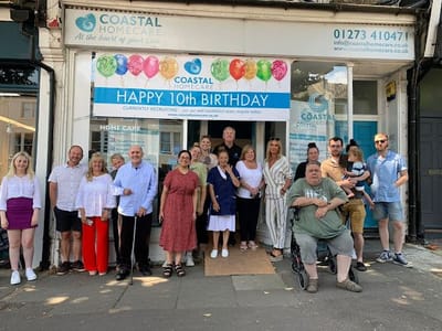 Group of staff and residents celebrating 10th birthday outside Coastal Homecare