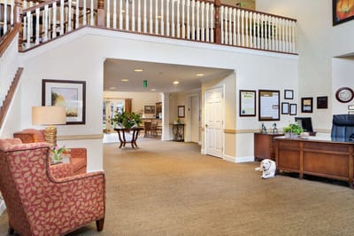 Bright lobby area with seating and a small dog