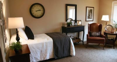 Cozy interior of a resident's room with bed and seating area