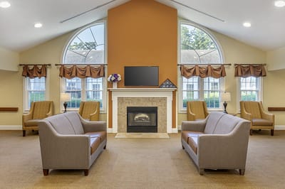 A cozy common area with seating around a fireplace