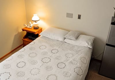 Cozy resident bedroom with lamp and decorated bedding