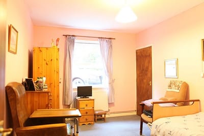 Cozy resident room with light pink walls and furniture