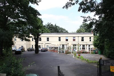 Exterior view of Forest Lodge Care Home surrounded by trees