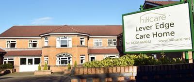 Exterior view of Lever Edge Care Home with signage