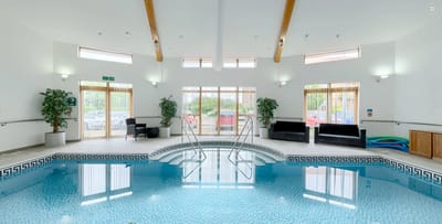 Indoor swimming pool area with lounge seating