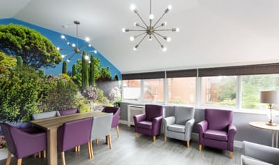 Bright common area with purple chairs and nature mural