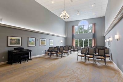 Bright and spacious common area with chairs and piano