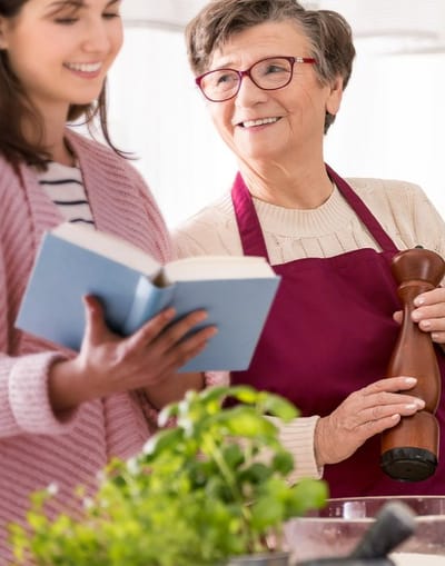 A caregiver and a senior resident cooking together