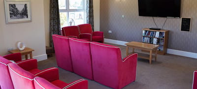 Common area with pink seating and a TV
