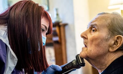 Caregiver providing grooming assistance to a senior resident
