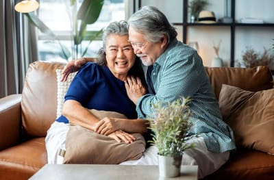 Senior couple sharing a joyful moment on a couch