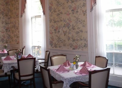 Dining area with floral wallpaper and table settings