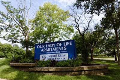 Sign for Our Lady of Life Apartments in a landscaped area