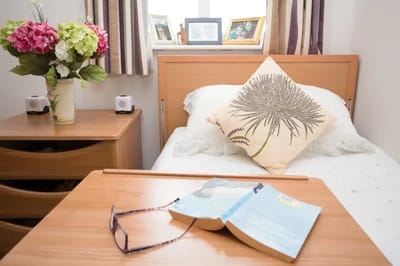 Cozy resident room with personal touches and a book