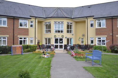 Exterior of Larkrise Care Centre with residents and garden