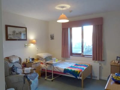 Cozy private resident room with a bed and chair