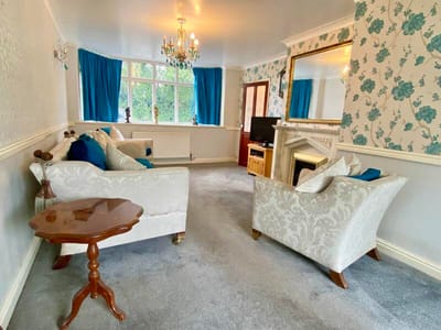 Bright and cozy common area with floral wallpaper and furniture