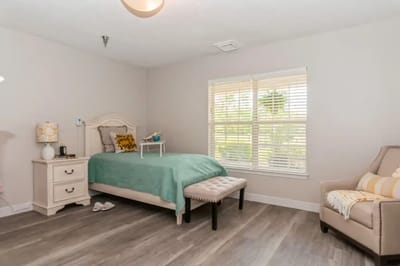 A cozy resident room with a bed and seating area