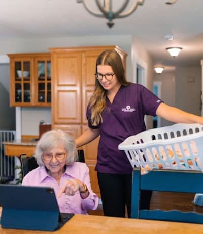 Care staff assisting a resident with a tablet